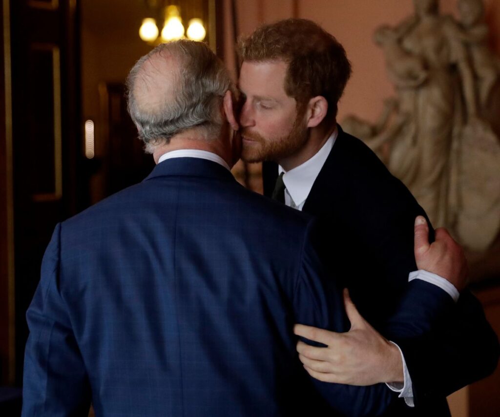 Prince Harry kissing King Charles on the cheek.