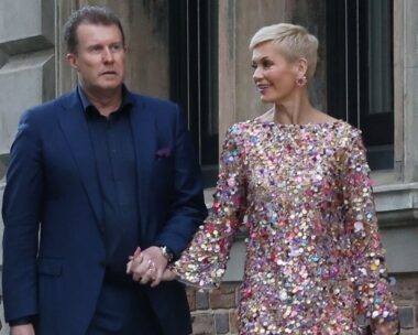 Pete, in a blue suit, and Jess, in a sequin dress, hold hands