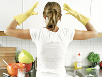 housewife in yellow gloves in kitchen 