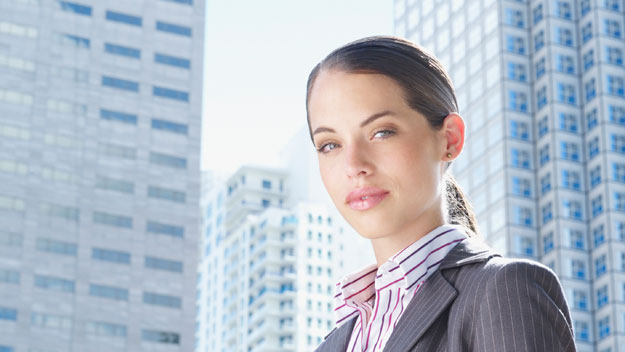 Women in business attire with city buildings in background, getty images 