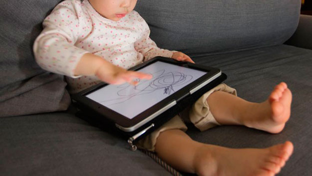A toddler playing with an iPad