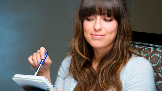 Brunette woman with notepad and pen
