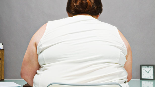 Overweight woman sitting backfaced in chair 