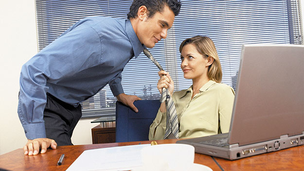 Woman pulling man by his tie at desk