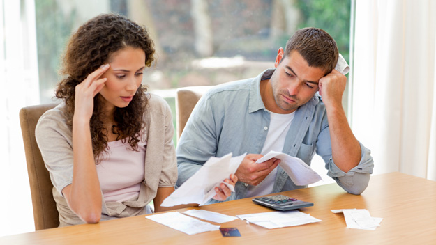 distressed couple looking at paperwork