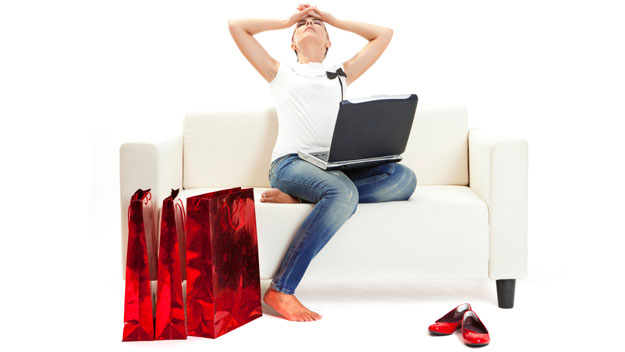 distressed woman with laptop and red shopping bags
