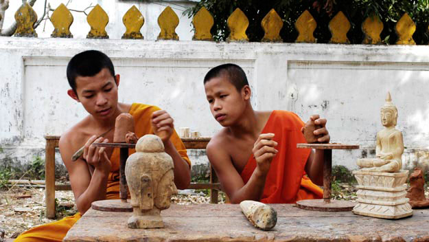 Novice monks learn how to sculpt Buddha heads from wood.