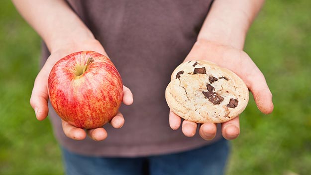 Photo: Michael Hevesy via Getty Images apple and cookie in each hand