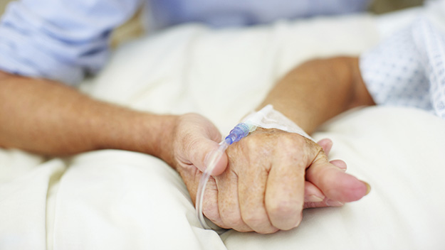 patient in hospital bed, hand with drip