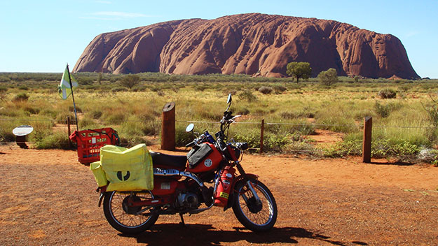Jacqui Kennedy's postie bike in front of Uluru.