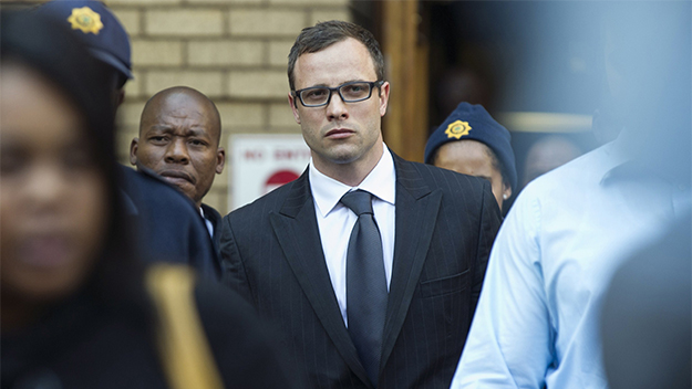 Oscar Pistorius leaves a South African court yesterday charged with the murder of his fiance Reeva Steenkamp