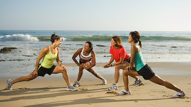 group of women exercising on the beach