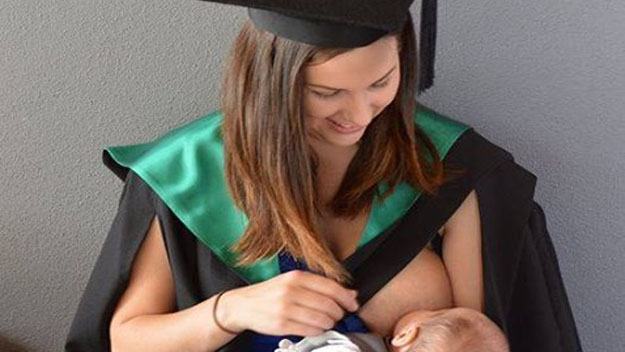 Woman breastfeeding baby at graduation 