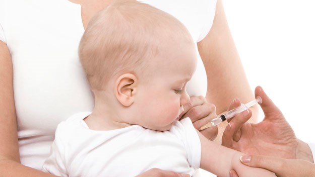 doctor injecting child with immunisation needle 