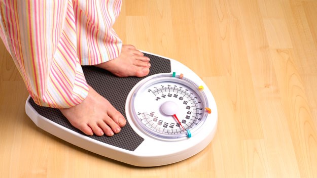 women standing on weight scale 