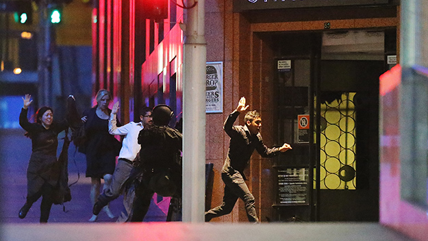 Hostages escaping the cafe through the fire door yesterday in Martin Place