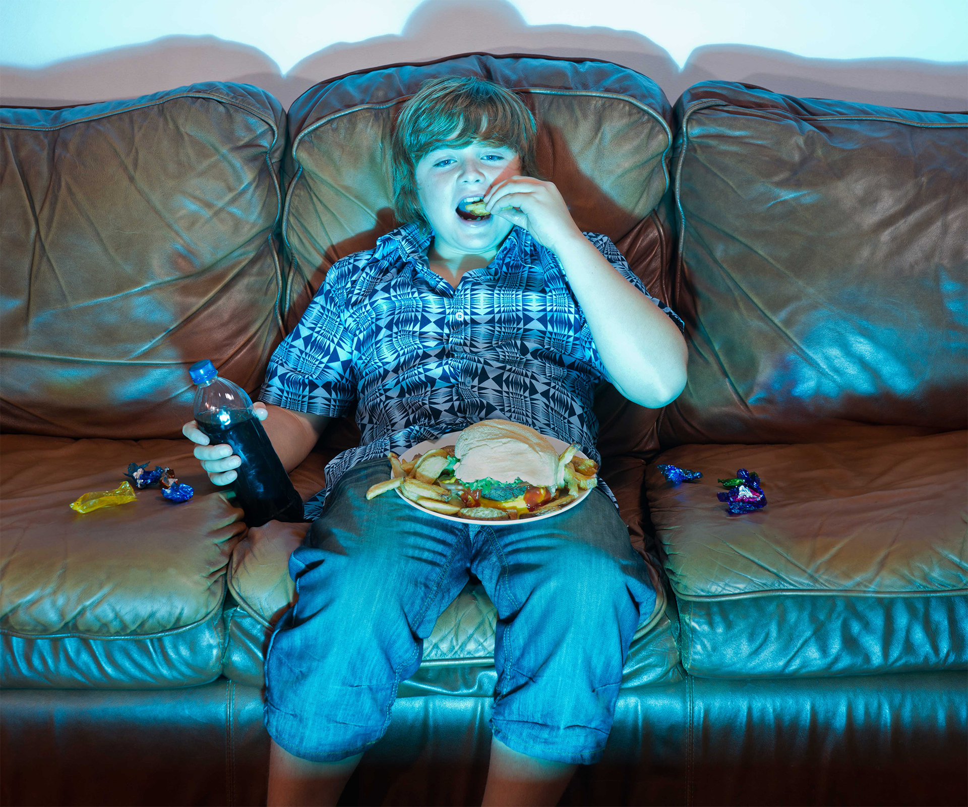 Boy eats food on lounge, stock image 