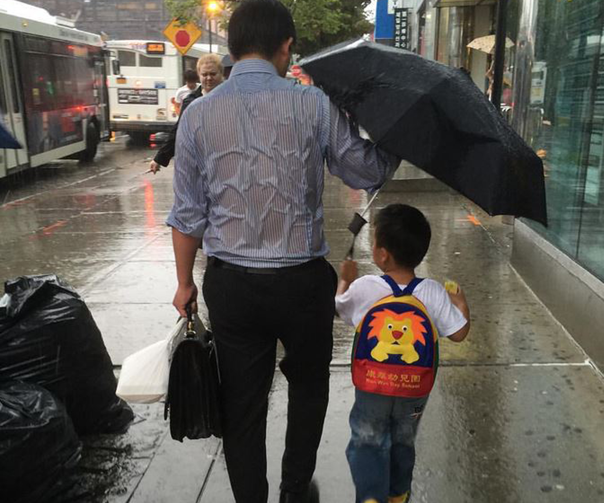 ‘Umbrella dad’ gets soaked to keep son dry