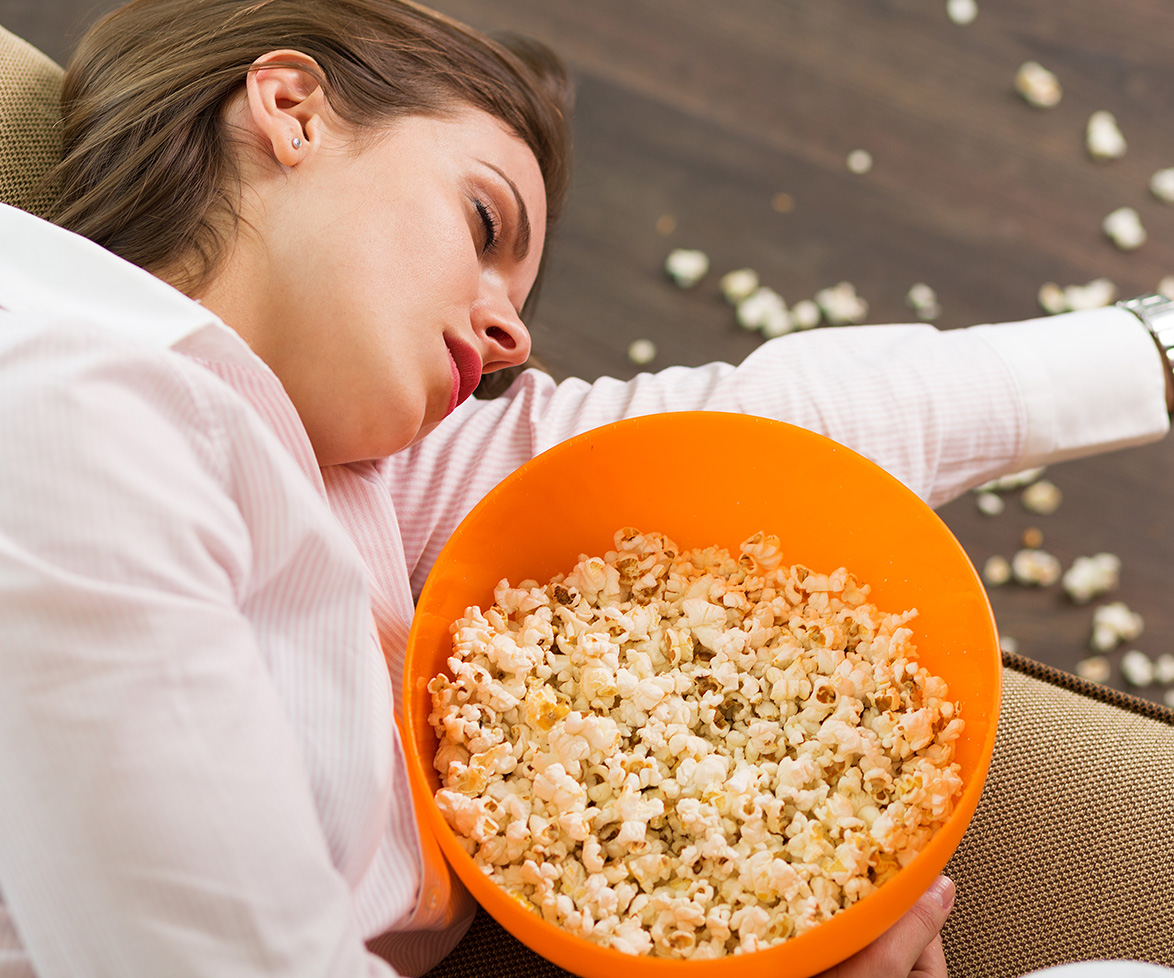 Woman in food coma with popcorn