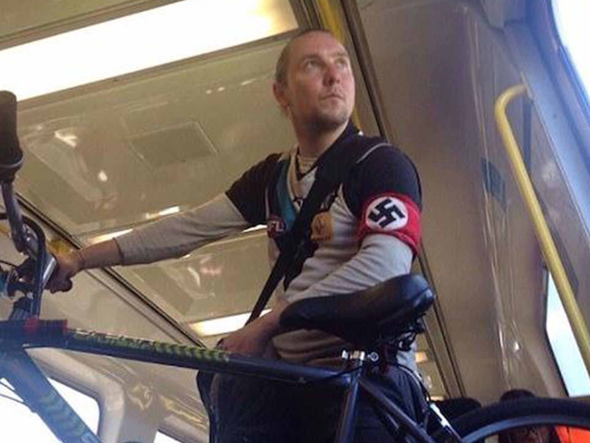 Real-life person wearing Nazi swastika outside of 1940s Germany