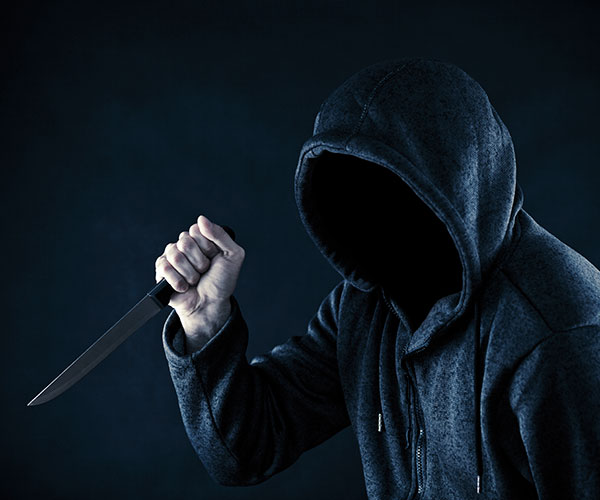 Hooded man holding a knife
