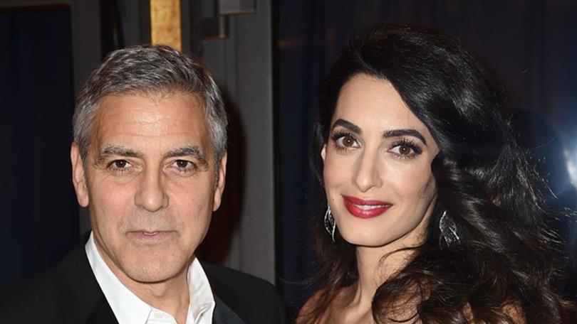 George and Amal Clooney handed out headphones to passengers sharing a flight with their twins